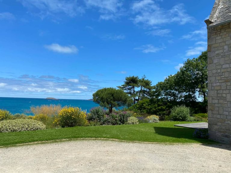 Jardin paysager entretenu avec pelouse et massifs fleuris face à la mer à Saint-Jacut-de-la-Mer